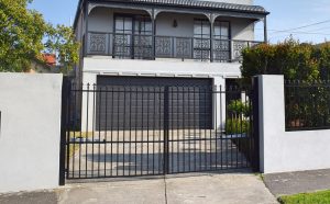Double Steel speer topped gate with rendered fence designed and built by Custom Built Fences