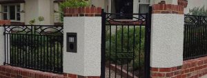Rendered pillars with brick capping and base fence designed and built by Custom Built Fences