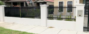 White rendered Pillars with Steel vertical slat infill designed and built by Custom Built Fences