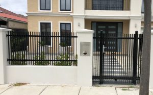 White rendered pillar fence with black powdere coated steel infillsdesigned and built by Custom Built Fences